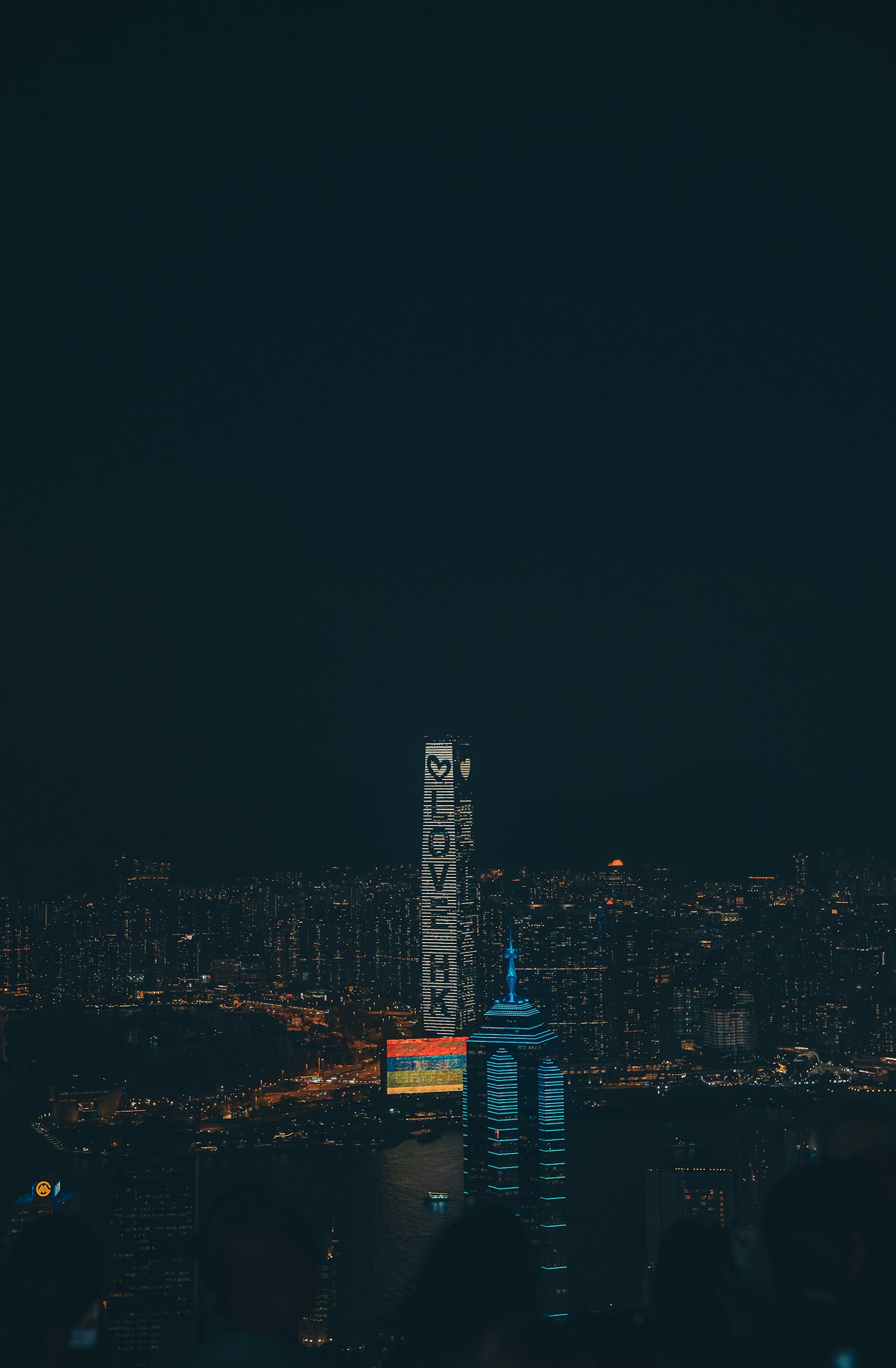 The Hong Kong skyline at dusk with city lights coming on