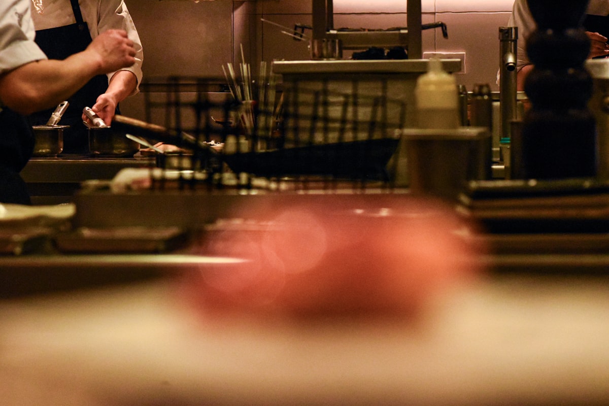 Chefs preparing and plating dishes during service in a busy restaurant kitchen