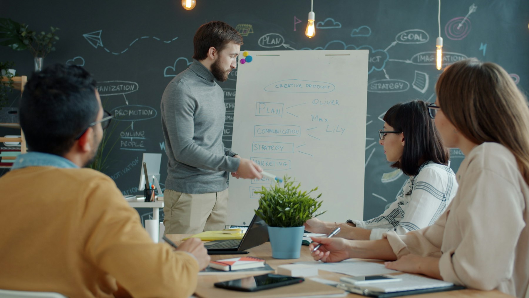 A team collaborating around a whiteboard in a bright, modern office